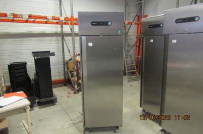 two refrigerators that are in a room with a lot of shelves