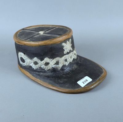 un petit chapeau noir orné d'une croix blanche