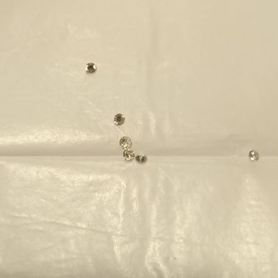 un lit recouvert d'un drap blanc, sur lequel sont posés deux clous