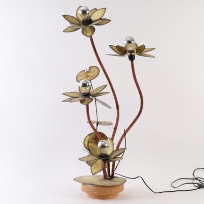 une photo d'une sculpture métallique représentant des fleurs, posée sur un socle en bois