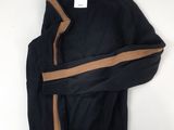 a black sweater with a brown stripe is hanging on a white wall