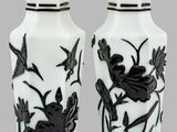 pair of black and white vases with birds and flowers on them
