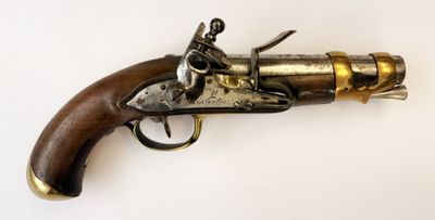gros plan d'un pistolet avec un manche en bois sur une surface blanche