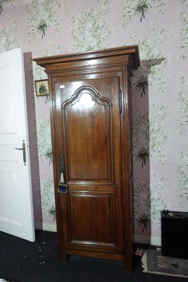 a tall wooden cabinet in the corner of a room