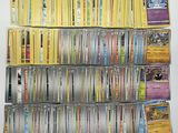 a large collection of pokemon trading cards on a white surface