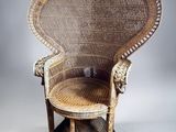 an old wicker chair with a wooden seat and foot rest