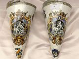 Deux vases sont posés sur une nappe blanche ornée d'un motif.
