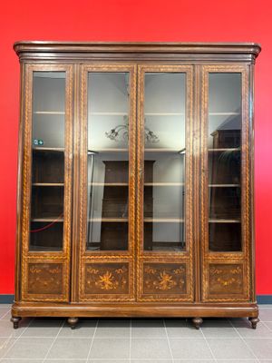 une photo d'une armoire en bois avec des portes vitrées, posée sur un sol carrelé