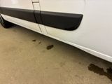 a white van with black trims parked in a garage