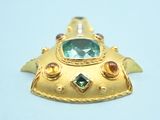 an image of a close up of a gold broochle on a white surface