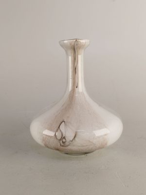 un vase en verre orné d'un papillon, posé sur une table
