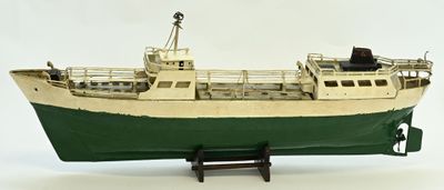 a model of a boat on a stand on a white surface