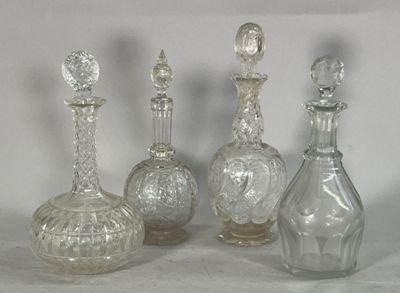 quatre bouteilles en verre transparent posées les unes à côté des autres sur une surface blanche