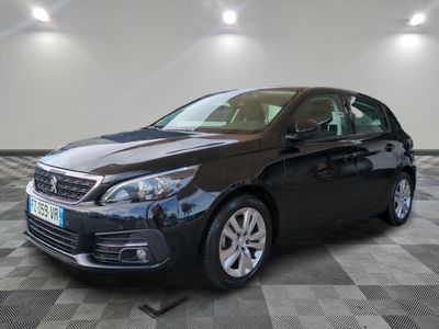 la voiture noire est garée sur un sol en damier dans le garage