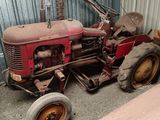 a red tractor parked in front of a building