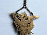brass necklace with a bird on a chain on a white background