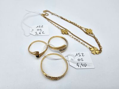a group of gold rings and necklaces on a white surface