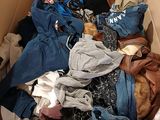 a box full of clothes and a cat sitting in it