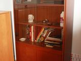 a wooden bookcase with many books on it in a room