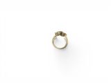 gros plan d'une bague en or sur une surface blanche