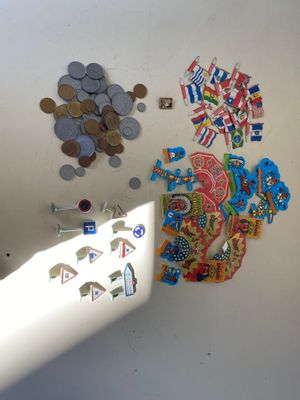 un réfrigérateur sur lequel sont accrochés des aimants et des pièces de monnaie