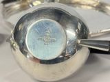 a silver tea pot with a handle on a table