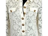a close up of a mannequin wearing a white jacket with gold buttons
