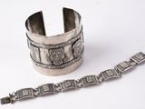 an old silver bracelet and a silver bracelet on a white surface