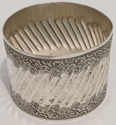 gros plan d'un bracelet en argent sur une surface blanche