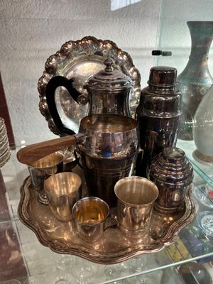 un plateau en argent sur lequel sont posées des tasses en argent et un pichet en argent