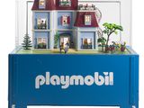 une vitrine Playmobil contenant une maison de poupées