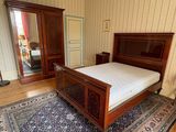 a bedroom with a bed, dresser, mirror, and rug