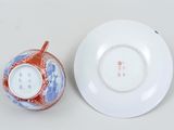 a white plate with a red and blue design on it next to a white plate with a red and blue design on it
