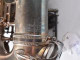 a close up of a silver saxophone with a tag on it
