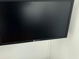 une télévision à écran plat fixée au mur au-dessus d'un bureau