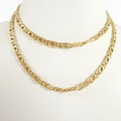 un gros plan sur un collier à chaîne en or porté par un mannequin