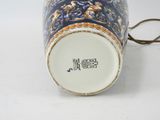 a close up of a vase with a handle on a white surface