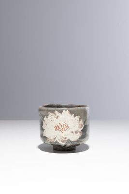 un petit bol orné d'une fleur, posé sur une table