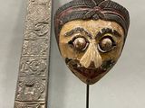 an image of a wooden mask next to a ruler on a table