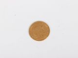 a close up of a gold coin on a white surface