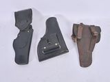 three different types of leather holsters on a white surface