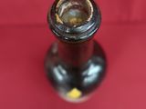 un petit vase noir orné d'une fleur jaune