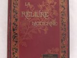un vieux livre à la couverture rouge posé sur une surface blanche