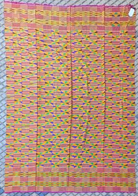 a close up of a pink and yellow rug on a bed