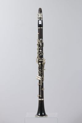 a close up of a clarinet on a stand against a white background