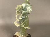 statue d'une femme en robe verte tenant une fleur