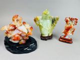 three figurines of different shapes and sizes on a white surface