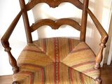 une chaise en bois dont l'assise et le dossier sont rayés