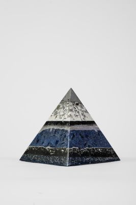 un gros plan d'un objet en forme de pyramide posé sur une surface blanche