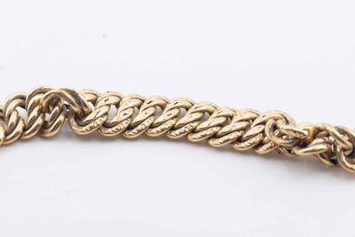 a close up of a gold chain bracelet on a white surface